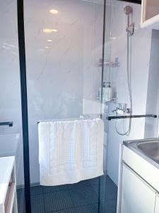 a white bathroom with a shower with a white chair at Youki Residence in Tokyo +20 photos