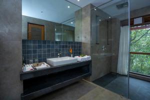 a bathroom with a sink and a large mirror at Vythiri Mist Resort in Vythiri +67 photos