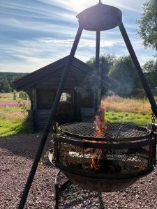 a fire grill in front of a cabin at Vörderåsgården in Transtrand
