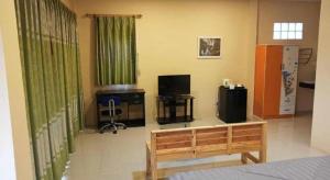 a living room with a couch and a television at Raisubsomboon Resort in Ban Don Wan