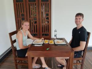 a man and a woman sitting at a table with food at Randiwa Homestay in Sigiriya +9 photos