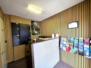 a restaurant with a counter with books on the wall at Arran Motel in Te Anau +24 photos