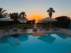 a swimming pool with a sunset in the background at Olgas Villa in Ayia Marina +33 photos