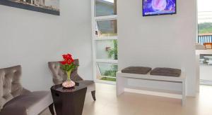 a living room with two chairs and a vase of flowers on a table at Soontree House Hotel in Udon Thani