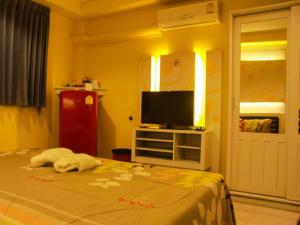 a bedroom with a bed and a flat screen tv at RungRoj Panich Hotel in Ban Bang Saen (1)