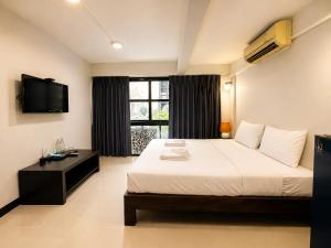 a bedroom with a large bed and a television at SaintLove Hotel in Chiang Mai