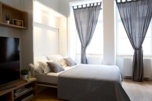 a bedroom with a bed and a tv and windows at Premium Class Apartments in Zagreb