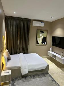 a bedroom with a large bed and a television at Grey Ivy Apartment in Abuja +13 photos