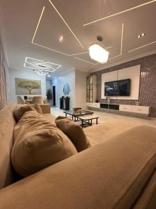 a large living room with a couch and a tv at Grey Ivy Apartment in Abuja