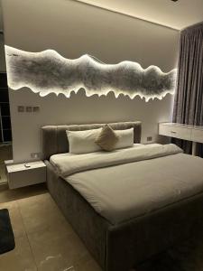 a bedroom with a bed with a cloud above it at Grey Ivy Apartment in Abuja