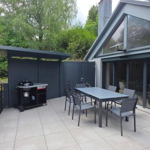 a patio with a table and chairs and a grill at Jardin De Pairis in Orbey
