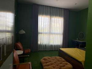 a bedroom with green walls and a bed and a window at She Stay in Hòa Bình +7 photos