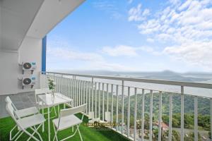 a balcony with a table and chairs and a view at Homecrown Relaxscape in Tagaytay
