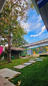 a park with a tree and a building with a mural at El Cacique Villeta Hostal in Villeta