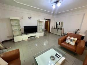 a living room with a couch and a tv at Résidence shalismi in Yaoundé