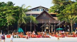a group of people sitting at tables in front of a building at Jirawan Hotel in Ko Samed