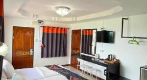 a bedroom with a bed and a desk with a telephone at Jirawan Hotel in Ko Samed