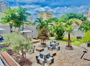 a patio with picnic tables and trees in a city at Anchan Hotel & Spa in Hua Hin