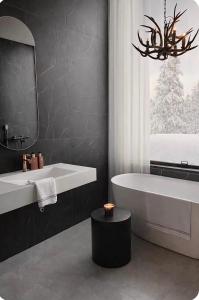 a bathroom with a tub and a sink and a mirror at Villa Blackreindeer in Kolari +50 photos