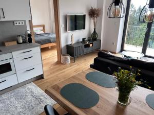 a living room with a couch and a table at Krkonoše - apartmán s výhledem in Benecko