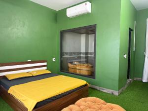 a bedroom with a bed and a green wall at She Stay in Hòa Bình
