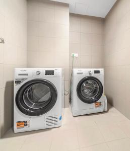 two washing machines sitting next to each other in a room at Krkonoše - apartmán s výhledem in Benecko