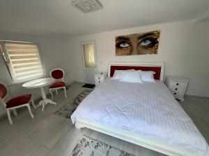 a bedroom with a white bed with two eyes on the wall at Lucatony's Guesthouse in Cîmpeni