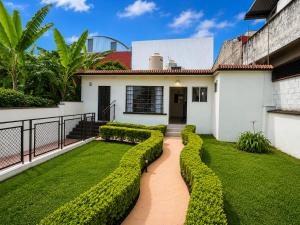 a house with green hedges in front of it at Hotel Ripoll Córdoba in Córdoba
