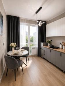 a kitchen and a dining room with a table and a kitchen at Elim-Ai in Kokshetau