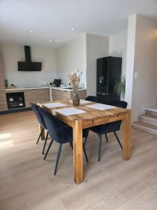 a wooden table and chairs in a living room at L'Escale Cosy avec Terasse in Noidans-lès-Vesoul