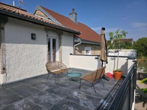 a patio with two chairs and a table and an umbrella at L'Escale Cosy avec Terasse in Noidans-lès-Vesoul