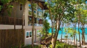 a building on the beach next to the ocean at Baan Supparod in Ko Samed