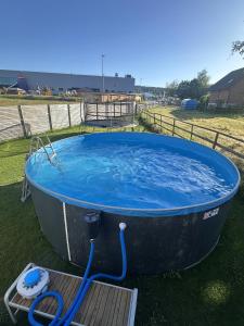 a large tub with a blue hose in the grass at Casa Stein am Rhein inkl Pool in Stein am Rhein