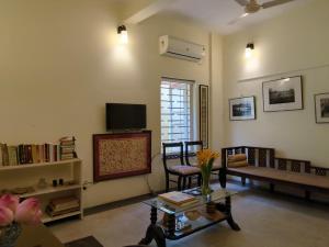 a living room with a tv and a couch and a table at Disharee 51A in Kolkata