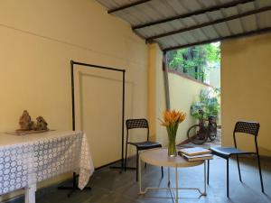 a room with a table and chairs and a table and a door at Disharee 51A in Kolkata