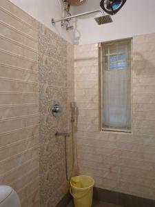 a bathroom with a shower with a toilet and a window at Disharee 51A in Kolkata +11 photos