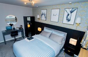 a bedroom with a bed with a desk and pictures on the wall at The Cheshire ABode- Central Warrington- Stadium, Station Access- Sleeps 5 in Warrington