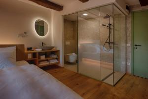 a bathroom with a shower and a bed and a sink at Posestvo Pri žabi in Štanjel +24 photos