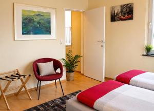 a bedroom with two beds and a chair and a painting at Holiday il Macellaio - nur 5 Min vom Marktplatz in Neustadt an der Weinstraße