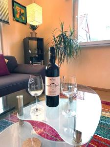 a bottle of wine sitting on a table with two wine glasses at Holiday il Macellaio - nur 5 Min vom Marktplatz in Neustadt an der Weinstraße