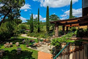 a patio with tables and chairs in a garden at Agriturismo Le Mandrie di Ripalta check in 15,00 - 19,00 in Montespertoli