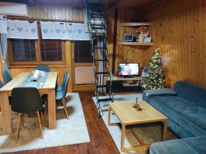 a living room with a christmas tree and a ladder at Chata Bobo in Stožok