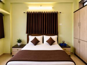 コールハープルにあるLaxmi Narayan Hotelの大きなベッドと枕のある寝室