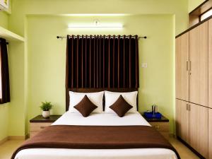 コールハープルにあるLaxmi Narayan Hotelの大きなベッドと窓のある寝室
