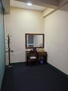 a room with a desk and a mirror at Hotel Velmont Kandy in Kandy