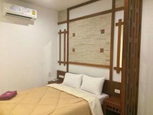 a small room with a bed with a window and avertisement at Suanrak Resort in Suphan Buri
