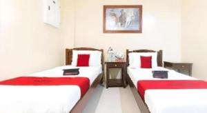 two beds in a room with red and white at Dino Residences in Daro