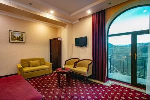 a hotel room with a couch and chairs and a window at Nairi Hotel in Jermuk