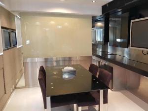 a dining room with a table and a tv at Acesite Knutsford Hotel in Hong Kong