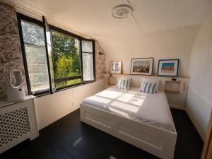 a bedroom with a white bed and two windows at Domaine de la Jasseix in Croze